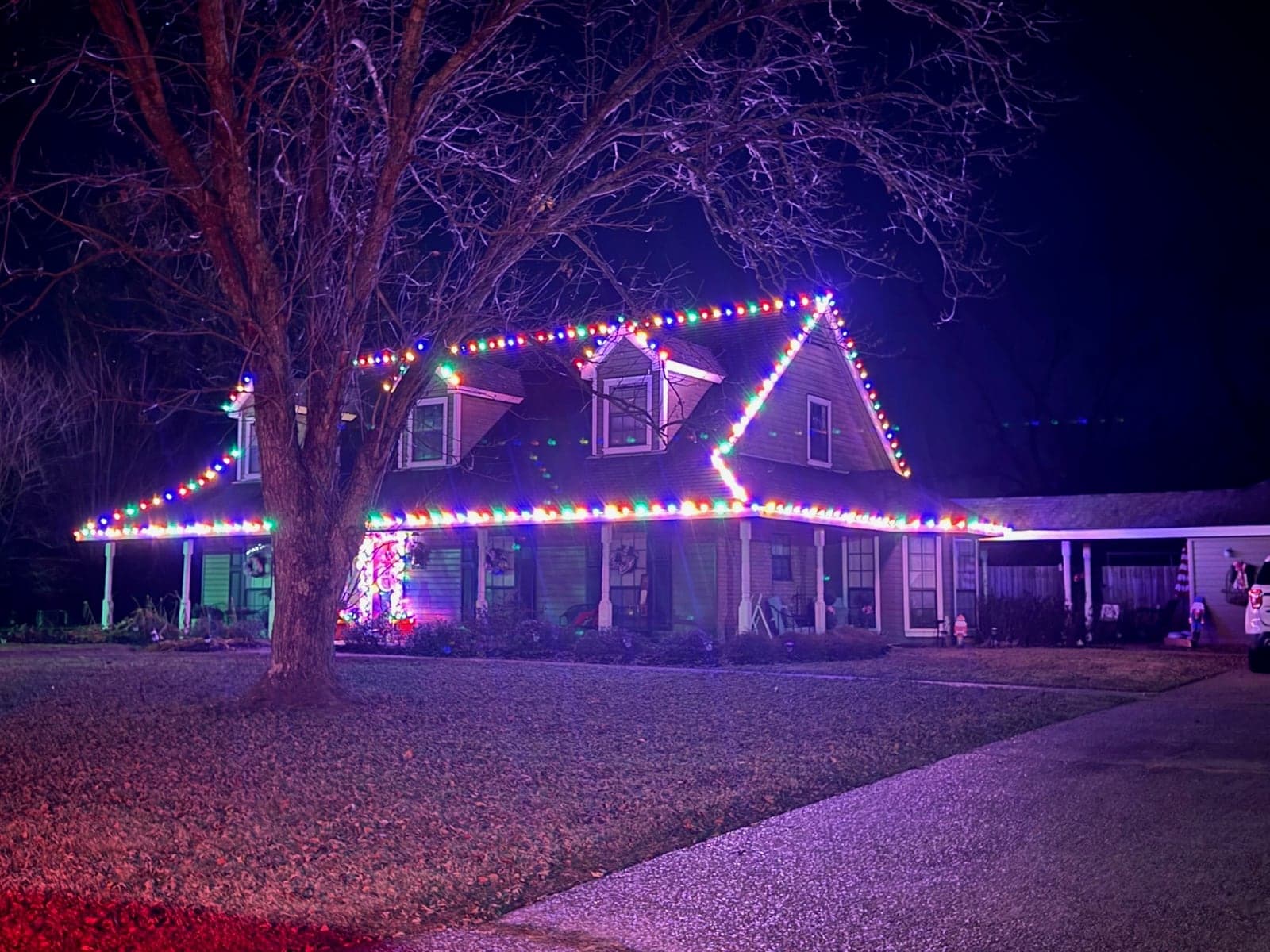 Two-story home outlined in multicolor C9 lights
