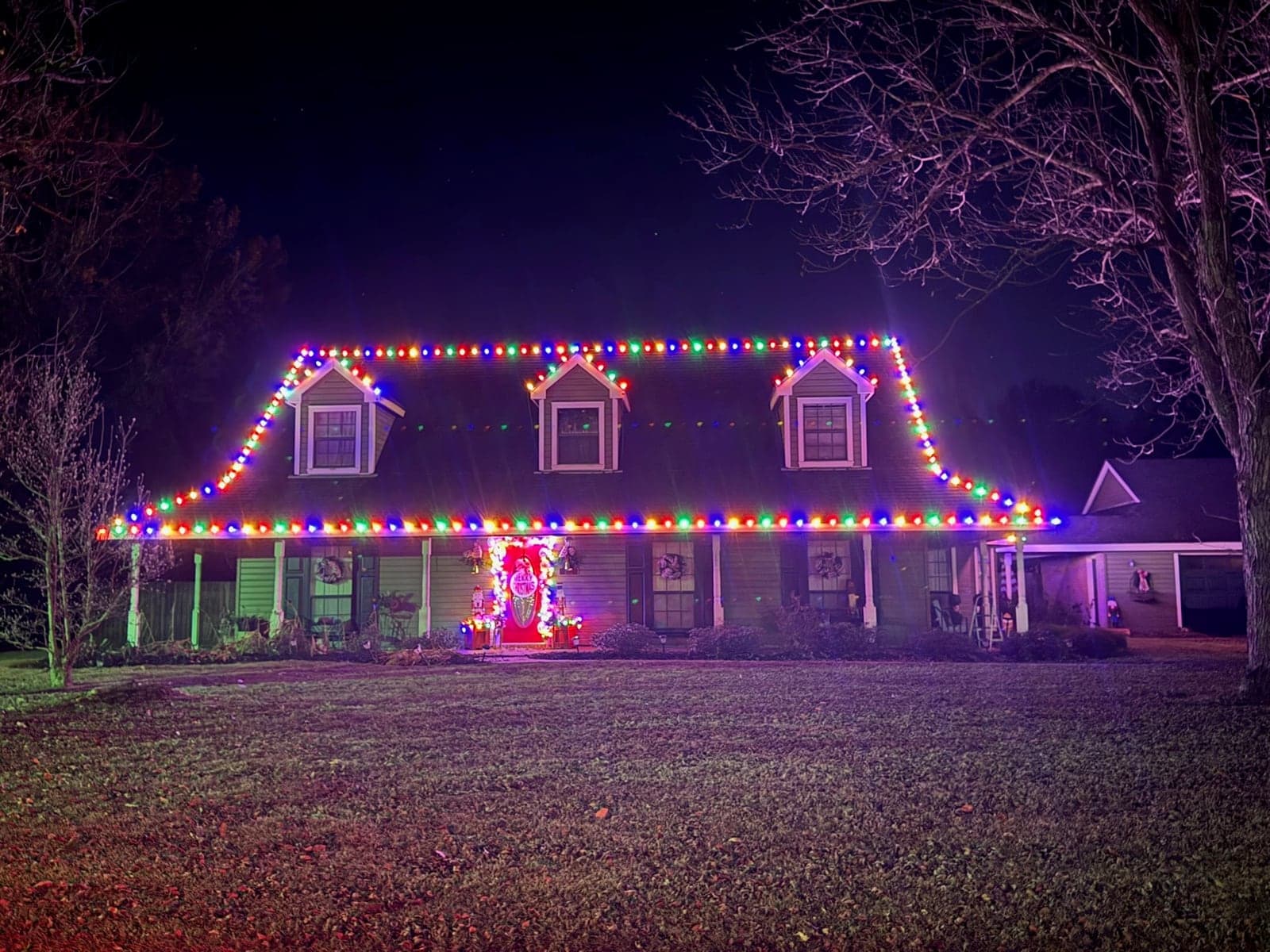 Home with dormers outlined in multicolor lights